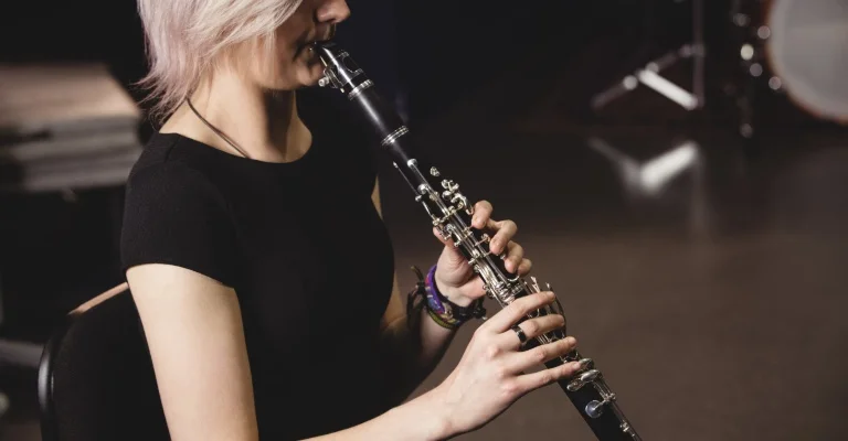 a woman playing clarinet sitting